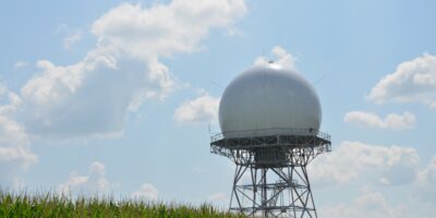 Weather radar dome with clouds on hilltop